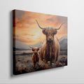 Framed canvas print of a Highland Cow and Calf against a vivid sunset landscape