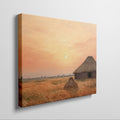 Framed canvas print of a rustic thatched cottage in a countryside landscape at sunset with warm golden and orange hues