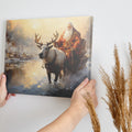 Framed canvas print of a mythical figure in red with a reindeer in a warm, snowy sunset landscape