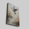 Framed canvas print of a heron soaring above a sepia-toned riverside scene with blooming reeds.