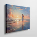 Framed canvas print of a woman walking on the beach at sunset with vibrant skies reflected in the water