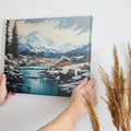 Framed canvas print of a serene mountain landscape with snow-covered peaks, a flowing river, and a forest in digital art style.