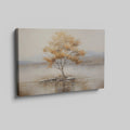 Framed canvas print of a solitary tree with autumn leaves reflected on a calm lake with warm beige, gold, and white tones