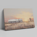 Framed canvas print of a rustic barn surrounded by tranquil fields at sunset, with warm golden and earthy tones.