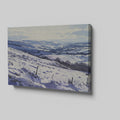 Framed canvas print of a snowy countryside landscape with rolling hills in cool blue tones