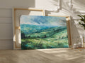 Framed canvas print of a watercolour countryside landscape with green rolling hills and vibrant skies