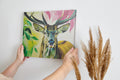 Framed canvas print of a colourful, modern artistic depiction of a stag with vibrant hues.