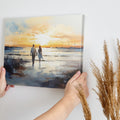 Framed canvas print of a couple walking on the beach at sunset with reflective water and warm colours