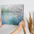 Framed canvas print of Cherry Blossoms by a Tranquil Lake with Pastel Colours