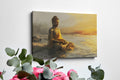 Wall canvas print of a meditative Buddha statue in golden and orange hues reflecting on tranquil waters at sunrise.