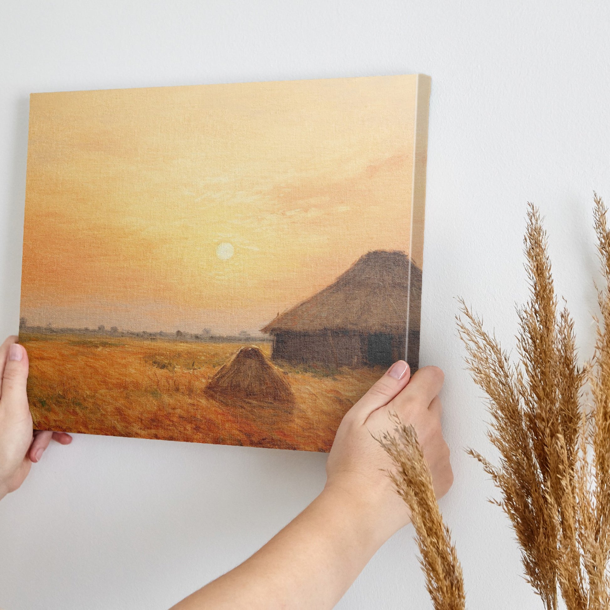 Framed canvas print of a rustic thatched cottage in a countryside landscape at sunset with warm golden and orange hues