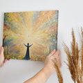 Framed canvas print of a figure silhouetted against a radiant background with mystical trees and glowing orbs.