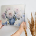 Framed canvas print of realistic dahlia flowers in a vintage blue vase with soft pastel tones