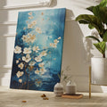 Framed canvas print of abstract blue and gold blossoms over a textured background