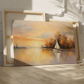 Framed canvas print of a sailboat during sunset with golden sky and water reflections