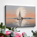 Framed canvas print of a sailboat at sunset with reflections on tranquil waters