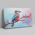 Framed canvas print of a colourful Kingfisher bird on a branch with pink cherry blossoms against a soft blue sky