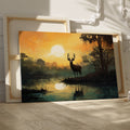 Framed canvas print of a majestic stag against a forest lake at sunrise with orange skies