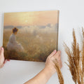 Framed canvas print of a woman in a white dress gazing at a misty sunrise over a golden field