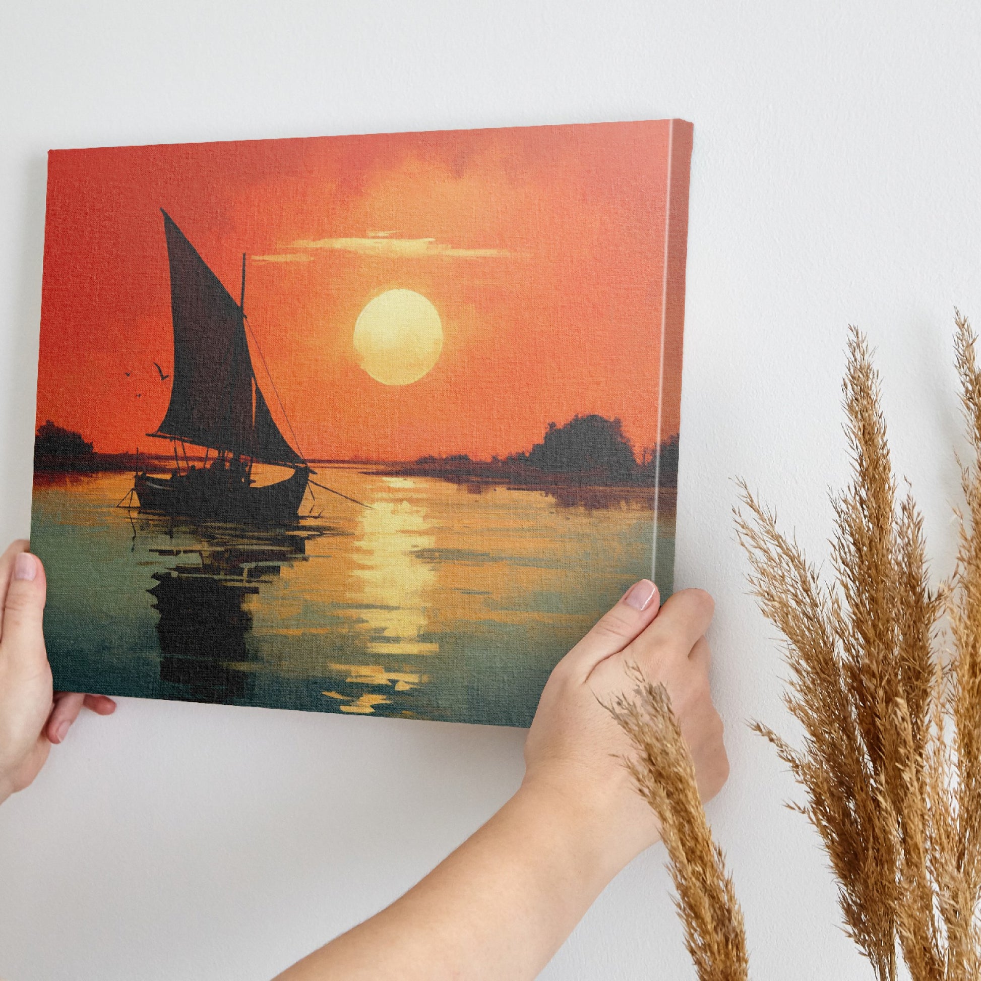 Framed canvas print of a sailboat against an orange sunset with water reflections