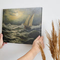 Framed canvas print of a classic maritime seascape with a sailing ship braving tumultuous ocean waves under a cloudy golden sky.