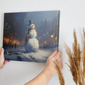 Framed canvas print of a snowman in a winter evening townscape with warm street lights and snowfall