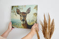 Framed canvas print of a realistic deer in a serene countryside setting with earthy tones