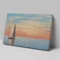 Sailboat on calming ocean waters during a vibrant sunset with orange and pink clouds in the sky.