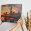 Framed canvas print of a colourful sunset over Big Ben and the London skyline, with stark reflections in the River Thames.