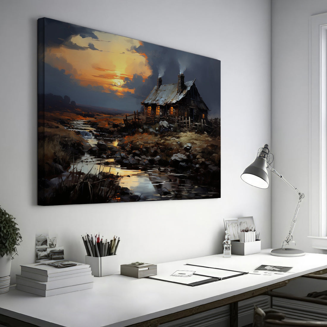 Framed canvas print of a rustic cottage with illuminated windows at sunset, set against a serene countryside landscape with a reflective creek.