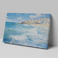 Framed canvas print of a Mediterranean village by the sea with vibrant blue waves and sunny sky