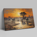 Framed canvas print of African elephants walking beside water during a vibrant sunset