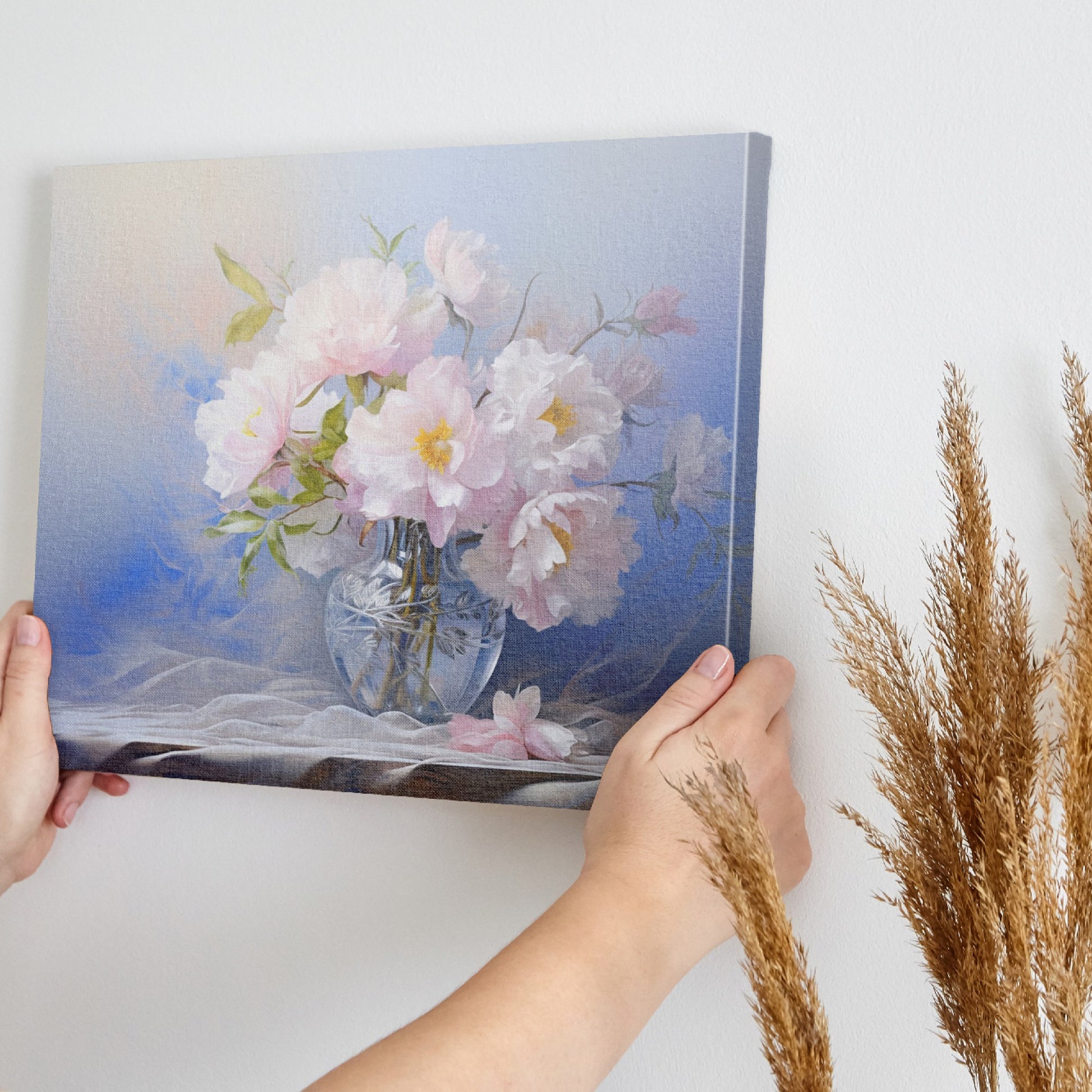 Framed canvas print of elegant pink peonies in an ornate glass vase portrayed with soft pastel colors