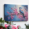 Framed canvas print of a bluebird perched on cherry blossom branches, with vibrant blue and pink hues