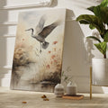 Framed canvas print of a heron soaring above a sepia-toned riverside scene with blooming reeds.