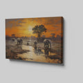 Framed canvas print of African elephants walking beside water during a vibrant sunset