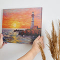 Framed canvas print of a vibrant impasto painting of a lighthouse at sunset with dynamic sea waves and a warm sky