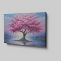 Framed canvas print of a blossoming cherry tree by the water with sunset reflection