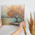 Framed canvas print of a textured autumnal tree with orange and gold foliage by a serene lake