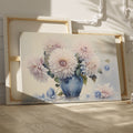 Framed canvas print of realistic dahlia flowers in a vintage blue vase with soft pastel tones