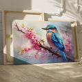 Framed canvas print of a vibrant kingfisher on a flowering cherry blossom branch