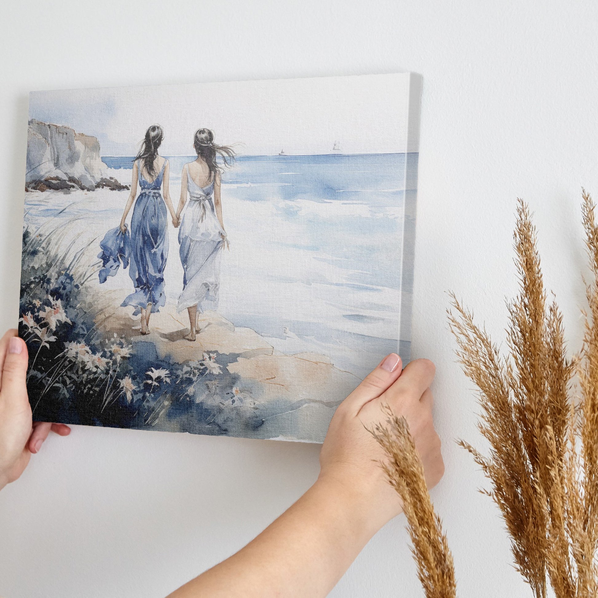 Watercolor painting of two women in blue and white dresses walking along a seaside cliff with a calm ocean backdrop