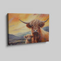 Framed canvas print of Highland cattle with calf at sunset, warm tones and mountain backdrop