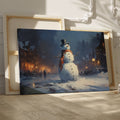 Framed canvas print of a snowman in a winter evening townscape with warm street lights and snowfall