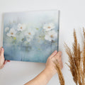 Framed canvas print of serene watercolor flowers with soft blue hues and water reflections