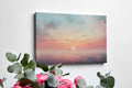 Framed canvas print of a tranquil seascape at sunset with birds and pastel skies