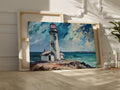 Framed canvas print of lighthouse on coastal rocks with dynamic sea and sky