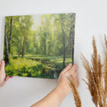 Framed canvas print of a lush forest scene with birch trees and a stream with sunlight filtering through green leaves