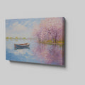 Framed canvas print of an impressionist painting featuring cherry blossoms and a serene lake with a boat