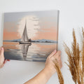 Framed canvas print of a sailboat at sunset with reflections on tranquil waters